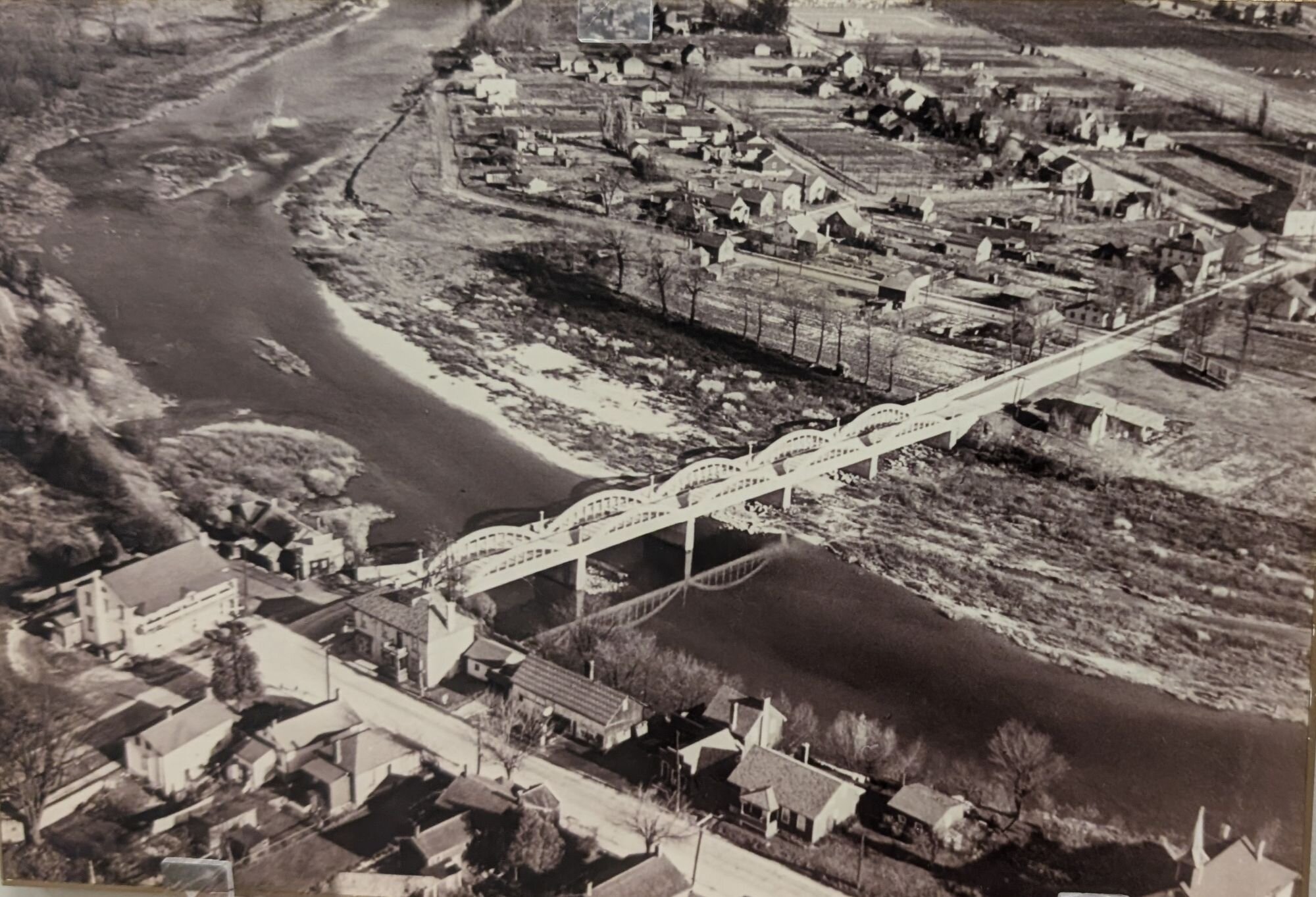 A historic aerial photograph of Bridgeport showing the arched bridge spanning the river and surrounding neighbourhood; this print is also displayed at the Bridgeport Community Centre.
